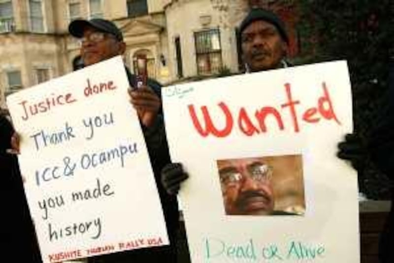 WASHINGTON - MARCH 05: Activists Mohamed Suleiman (R) and Khalid Gerais (L) hold posters as they protest in front of the Sudanese Embassy March 5, 2009 in Washington, DC. The International Criminal Court has ordered the arrest of Sudanese President Omar Hassan al-Bashir to face war crime charges including pillage, torture, rape, murder, and displacement of large numbers of civilians in Darfur.   Alex Wong/Getty Images/AFP
== FOR NEWSPAPERS, INTERNET, TELCOS & TELEVISION USE ONLY ==