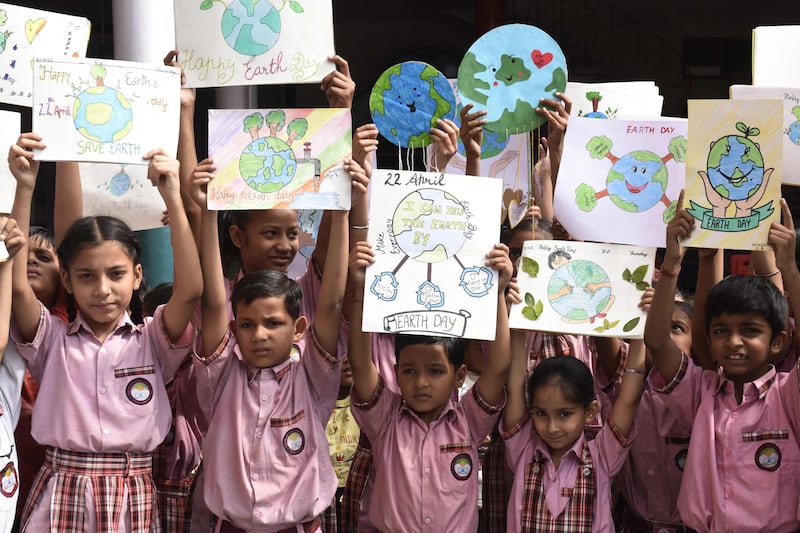 Students hold their paintings with environmental themes as they gather on the occasion of 'Earth Day' at a school in Amritsar. AFP
