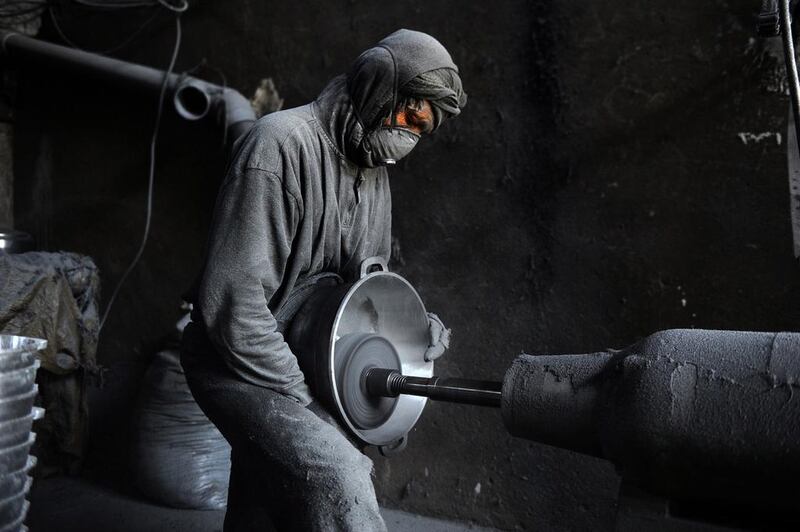 A labourer polishes a metal pot at an aluminium workshop in Herat.