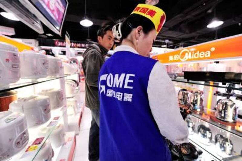 A shop assistant in Gome chats to a customer in a store in Beijing on November 24, 2008. China's second-richest person, Huang Guangyu who made his fortune building up Gome, the nation's largest home appliance chain, has been detained on suspicion of market manipulation, state media reported. AFP PHOTO/Peter PARKS