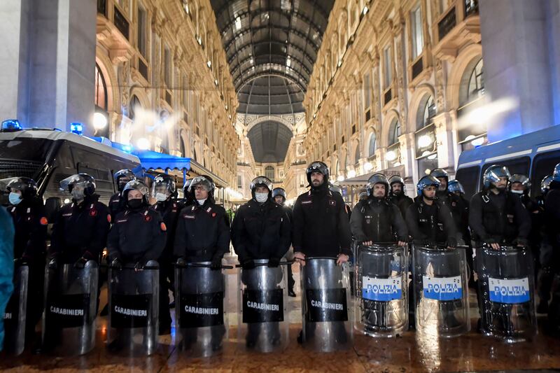 Riot police patrol the Galleria Vittorio Emanuele II shopping arcade during a protest against the Covid-19 vaccination green pass, in Milan. AP