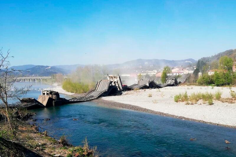 Smoke and dirt rise after a bridge collapsed on a river bed, in Aulla, between the regions of Tuscany and Liguria, northern Italy, AP