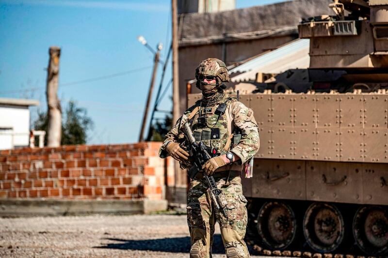 A US soldier stands by a Bradley Fighting Vehicle (BFV) during a patrol in the countryside near al-Malikiyah (Derik) in Syria's northeastern Hasakah province on February 2, 2021.  / AFP / Delil SOULEIMAN
