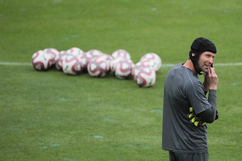 Goalkeeper Petr Cech puts on protective headgear during a team training session. EPA
