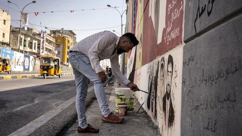 Mustafa Abd painting one of his artworks in Al Sadoon tunnel next to Tahrir square preparing for the anniversary of the protests. Haider Husseini for The National