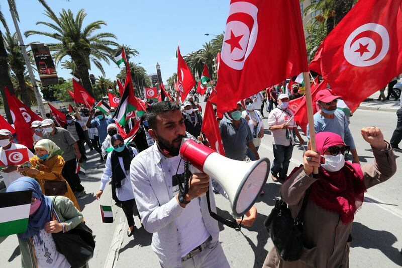 epa09212087 Tunisians wave Palestinian flags and chant anti-Israel slogans during a demonstration in solidarity with Palestinians in Tunis, Tunisia, 19 May 2021. In response to days of violent confrontations between Israeli security forces and Palestinians in Jerusalem, various Palestinian militant factions in Gaza launched rocket attacks since 10 May that killed at least 12 Israelis to date. The Palestinian health ministry said that at least 213 Palestinians, including 61 children, were killed in the retaliatory Israeli airstrikes.  EPA/MOHAMED MESSARA