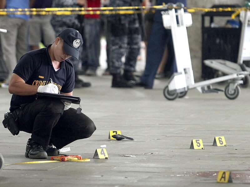 A police investigator works at the crime scene after a local town mayor was ambushed in a shooting attack at Manila's Ninoy Aquino International Airport . Che Cillo / Reuters