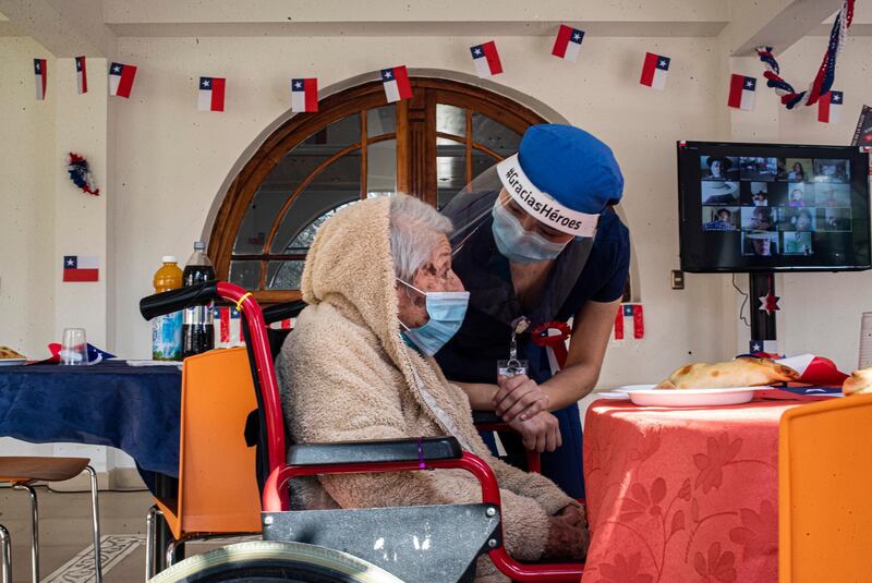 An employee chats with a resident who had been infected with the new coronavirus at a nursing home in Santiago, Chile. AP Photo