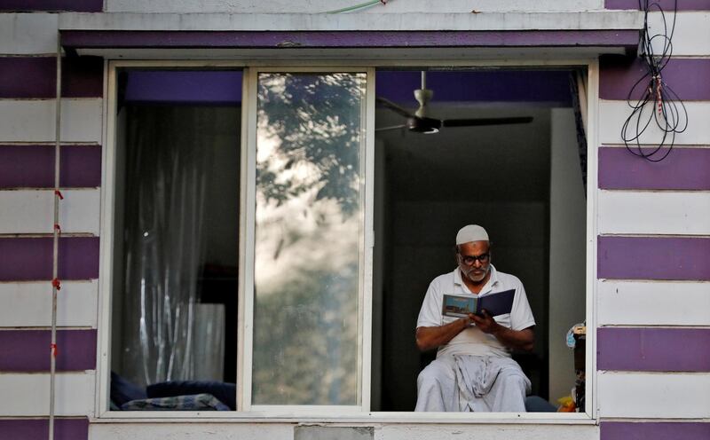 A man reads the Koran by the window of his house during the Muslim fasting month of Ramadan, during a nationwide lockdown to slow the spread of the coronavirus disease (COVID-19), in Ahmedabad, India, April 26, 2020. REUTERS/Amit Dave