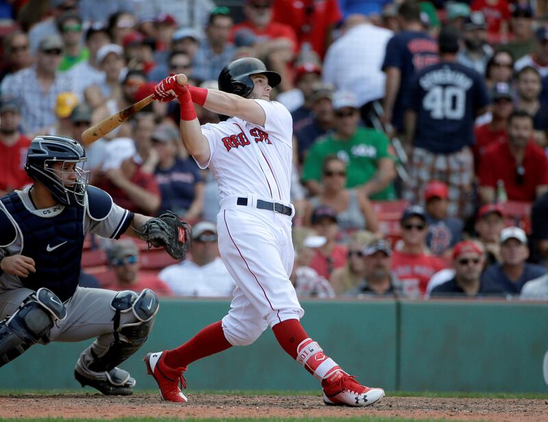 Boston Red Sox's Andrew Benintendi, right, takes his at bat as New York Yankees' Gary Sanchez, left, looks on in the eighth inning of a baseball game, Sunday, Aug. 20, 2017, in Boston. (AP Photo/Steven Senne)