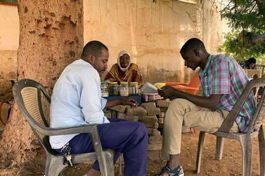 A Sudanese tea lady with two customers at her stall in the city of Omdurman. Hamza Hendawi for The National