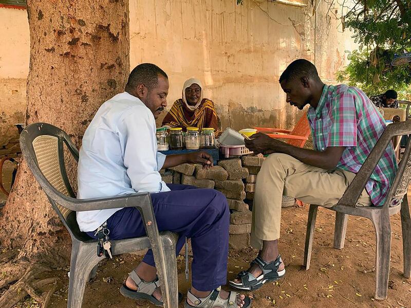 A Sudanese tea lady with two customers at her stall in the city of Omdurman. Hamza Hendawi for The National