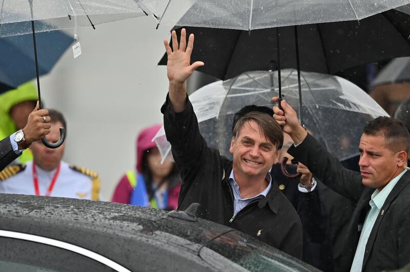 Brazilian President Jair Bolsonaro waves as he arrives in Osaka. AFP
