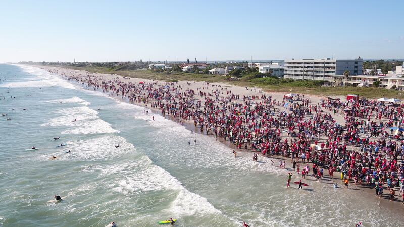 Thousands turned out to watch the Santas catch a wave or two. Reuters