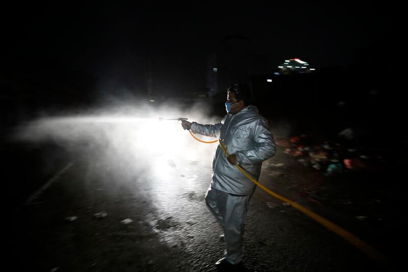 A Yemeni volunteer wearing a protective suit sprays disinfectant at a neighborhood amid the ongoing coronavirus pandemic in Sanaa, Yemen.  EPA