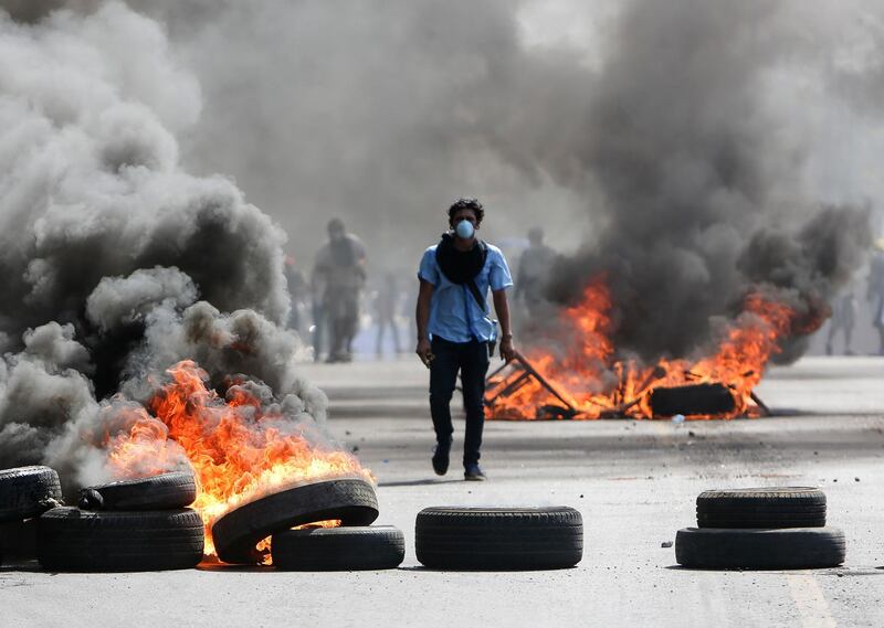A masked protester walks between burning barricades in Managua, Nicaragua, Friday, April 20, 2018. The clashes, pitting protesters opposed to social security reforms against riot police and pro-government groups, have rocked the capital, and a half-dozen other cities over the last three days. Alfredo Zuniga / AP Photo