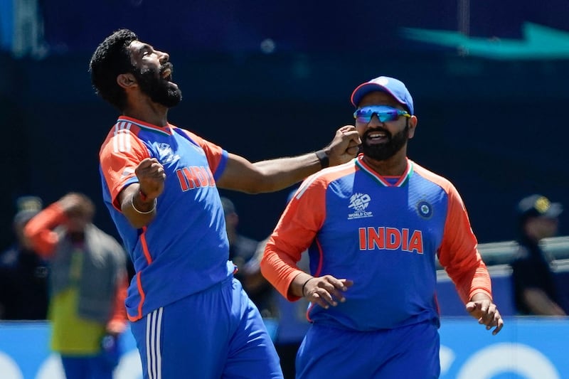 (L-R) India's Jasprit Bumrah celebrates with teammate Rohit Sharma after Pakistan's Azam Khan was dismissed during the ICC men's Twenty20 World Cup 2024 group A cricket match between India and Pakistan at Nassau County International Cricket Stadium in East Meadow, New York on June 9, 2024.  (Photo by TIMOTHY A.  CLARY  /  AFP)