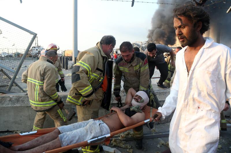 An injured man is rescued from the scene of an explosion at the Beirut port.  EPA