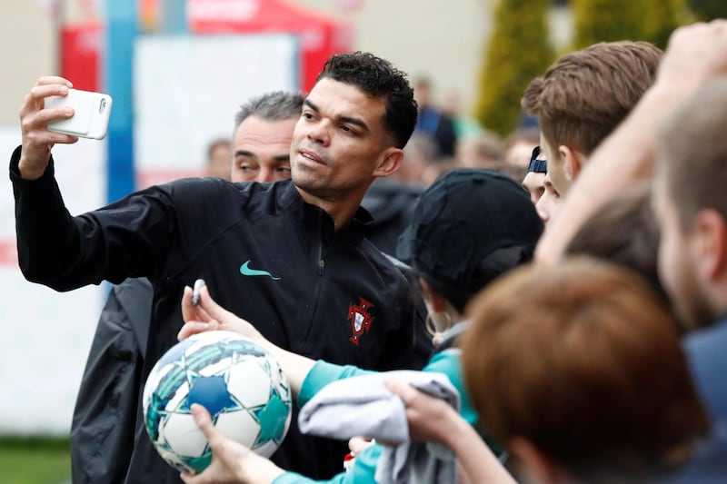 Pepe takes pictures with fans during Portugal's training session. Sergei Karpukhin / Reuters