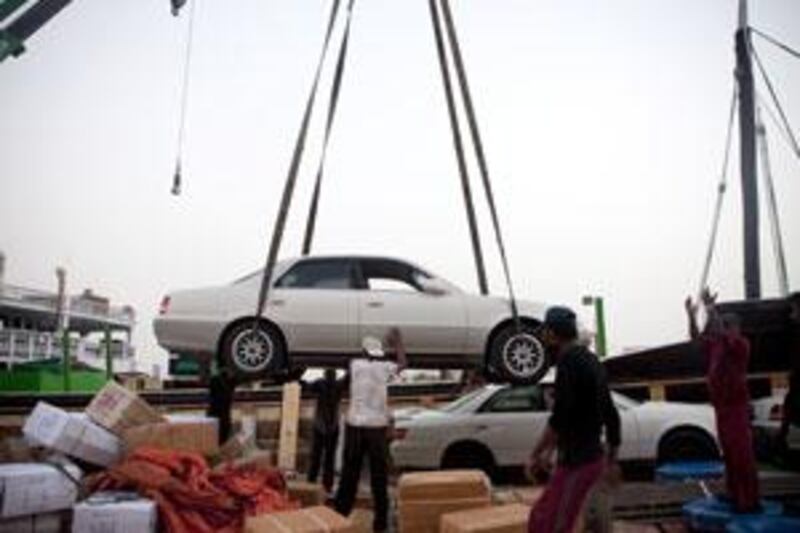 Somali ship workers hoist used cars onto a dhow headed for Berbera, Somalia.