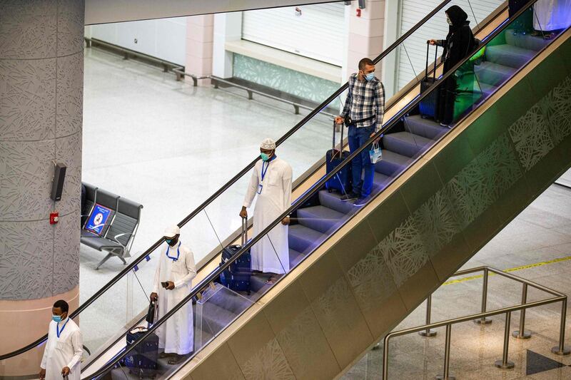 A handout picture provided by the Saudi Ministry of Hajj and Umra on July 25, 2020, shows travellers, mask-clad due to the COVID-19 coronavirus pandemic, descending an escalator with luggage as part of the first group of arrivals for the annual Hajj pilgrimage, at the Red Sea coastal city of Jeddah's King Abdulaziz International Airport. The 2020 hajj season, which has been scaled back dramatically to include only around 1,000 Muslim pilgrims as Saudi Arabia battles a coronavirus surge, is set to begin on July 29. Some 2.5 million people from all over the world usually participate in the ritual that takes place over several days, centred on the holy city of Mecca. This year's hajj will be held under strict hygiene protocols, with access limited to pilgrims under 65 years old and without any chronic illnesses. - === RESTRICTED TO EDITORIAL USE - MANDATORY CREDIT "AFP PHOTO / HO / MINISTRY OF HAJJ AND UMRA" - NO MARKETING NO ADVERTISING CAMPAIGNS - DISTRIBUTED AS A SERVICE TO CLIENTS ===
 / AFP / Saudi Ministry of Hajj and Umra / - / === RESTRICTED TO EDITORIAL USE - MANDATORY CREDIT "AFP PHOTO / HO / MINISTRY OF HAJJ AND UMRA" - NO MARKETING NO ADVERTISING CAMPAIGNS - DISTRIBUTED AS A SERVICE TO CLIENTS ===
