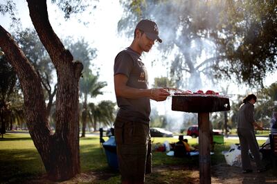 January 8, 2010 / Abu Dhabi / (Rich-Joseph Facun / The National) Ahmad Abuyousef (CQ) works the grill while barbecuing with family members at a park on 15th Street, Friday, January 8, 2009 in Abu Dhabi. The family said they typically barbeque together two to three times a month.