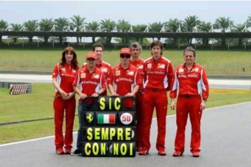Members of the Ferrari team pay tribute to Marco Simoncelli, the Italian MotoGP rider, who was killed in a crash in Malaysia.