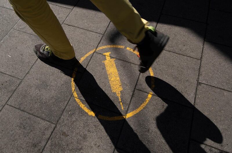An illustration of a syringe is used to indicate the city's vaccination centre to pedestrians in Osnabrueck, Germany. AP Photo