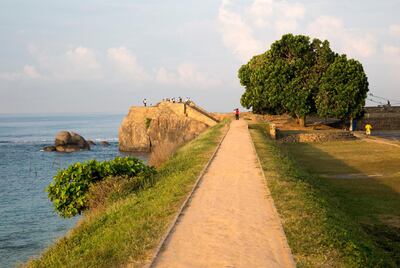 Tourists walk on fort ramparts in historic town of Galle, Sri Lanka, Asia. (Photo by: GeographyPhotos/UIG via Getty Images)