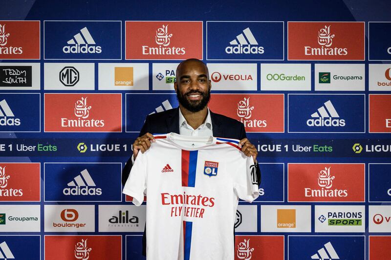 Alexandre Lacazette holds up a Lyon shirt during a press conference to announce his return to the club on a three-year contract. AFP