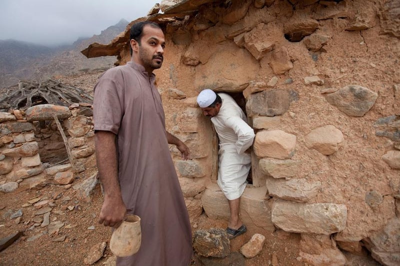 UAE - Fujairah - Jan 18 - 2011: Rashid Al Hufayti (left) and Hassan Al Hufayti check inside the remains of a house of the WAMM village in Dibba. ( Jaime Puebla - The National Newspaper ) "forgotten villages"