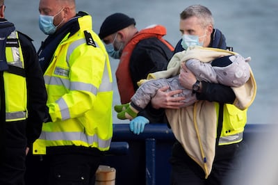 A baby child among migrants helped ashore from a UK Border Force vessel  in Dover. AFP