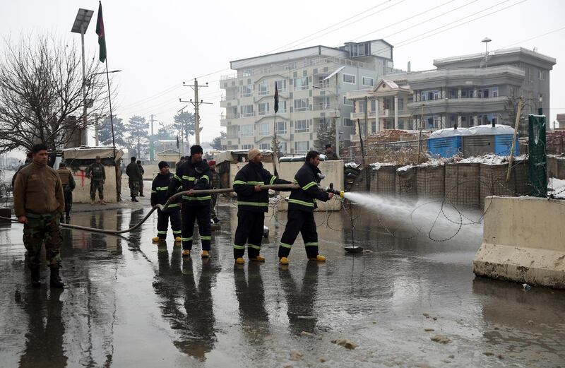 Firefighters clean the site of a suicide attack near the military academy in Kabul, Afghanistan. AP Photo