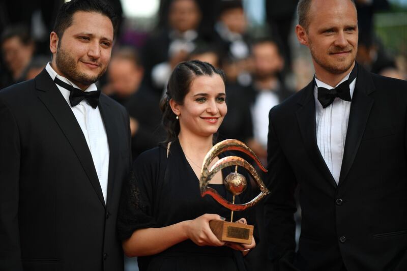 (FromL) Syrian actor Hamza al-Kateab, Syrian director and producer Waad al-Kateab and British director Edward Watts pose with the Oeil d'Or prize as they arrive for the screening of the film "The Specials (Hors Normes)" at the 72nd edition of the Cannes Film Festival in Cannes, southern France, on May 25, 2019.  / AFP / LOIC VENANCE
