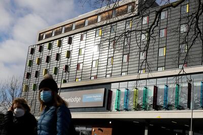 Pedestrians pass a hotel near Heathrow Airport in London, Friday, Feb. 5, 2021. British officials say everyone arriving in the country from coronavirus hotspots will have to spend 10 days in hotel quarantine starting Feb. 15 in a bid to stop new variants of the virus reaching the country. (AP Photo/Kirsty Wigglesworth)