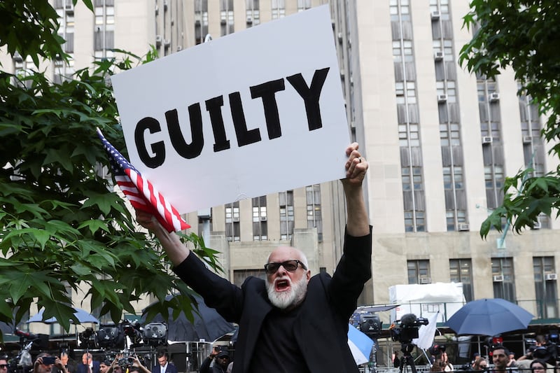 A man holds a placard outside Manhattan criminal court following the verdict. Reuters