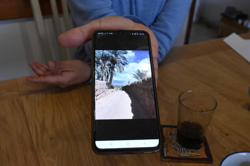 Moshe Shitrit holds a phone with a picture of his family's village in Morocco. Rosie Scammell for the National