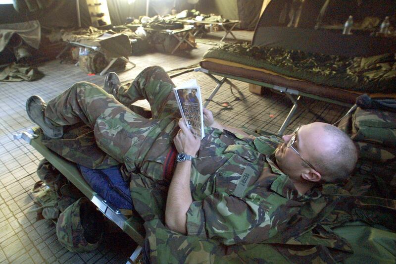 400262 05: Fred Perry, a British Royal Engineer soldier, reads the book "Black Hawk Down" inside his tent after a day of work January 29, 2002 at the International Security Assistance Force (ISAF) barracks at the Kabul airport in Kabul, Afghanistan. A United Nations mandated International Security and Assistance Force, made up of over 4, 000 foreign troops from 17 countries, regularly patrol the city, to improve security in the area. (Photo by Paula Bronstein/Getty Images)