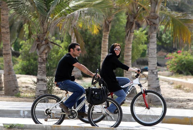 An man and woman ride hired bicycles on Kish Island. AFP