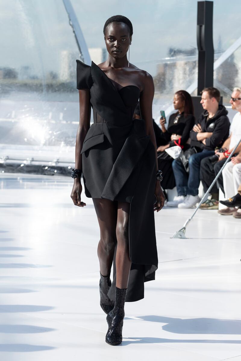 A black one-shouldered tuxedo dress with an exposed corset. 