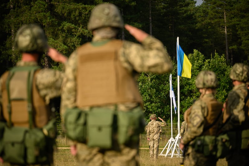 Ukrainian recruits salute the flag as they attend a commemorative service marking Ukraine's Independence Day, in August 2023, in a training camp in the south of England. Getty Images