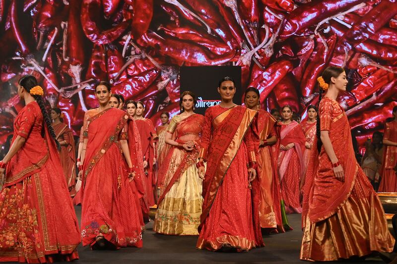 Bollywood actress Aditi Rao Hydari, in golden skirt, presents a creation by designer Gaurang. AFP
