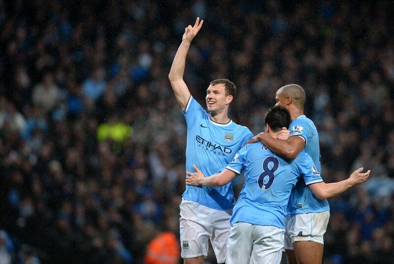 Manchester City striker Edin Dzeko celebrates scoring his second goal with midfielder Samir Nasri and Vincent Kompany on Wednesday. Andrew Yates / AFP / May 7, 2014