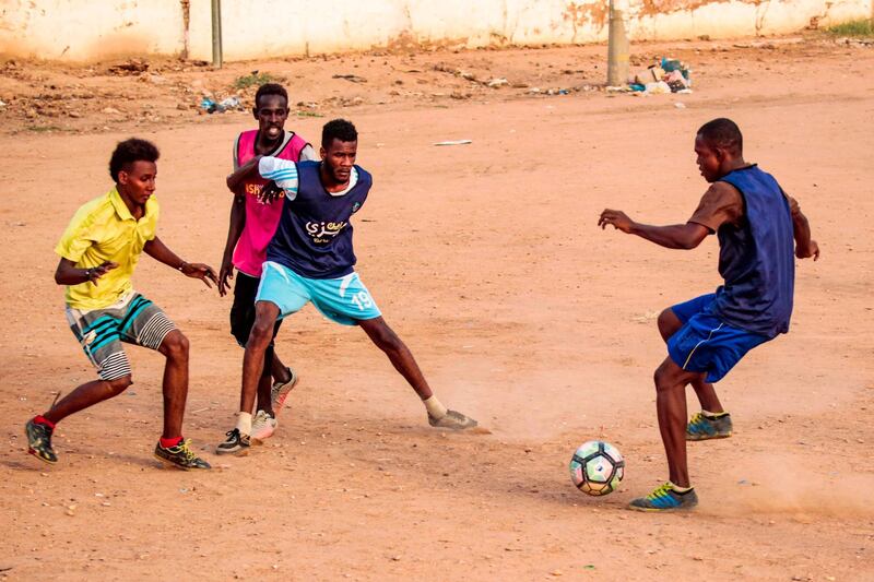 Sudanese youths play football on a dirt field in the capital Khartoum.