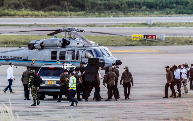 Colombia's President Ivan Duque walks surrounded by bodyguards close to the presidential helicopter at the tarmac of the Camilo Daza International Airport after it was hit by gunfire in Cucuta, Colombia. AFP