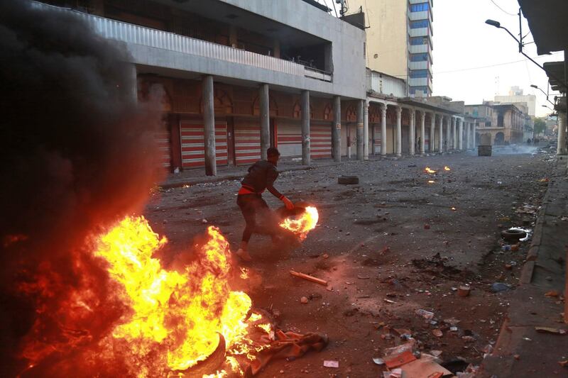 Riot police fire tear gas while protesters set fires during clashes. AP Photo