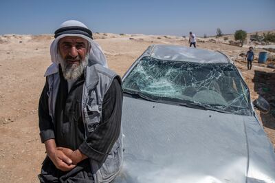 A Palestinian man leans on his smashed vehicle following an attack by settlers on his Bedouin community in the West Bank village of Al Mufagara. AP