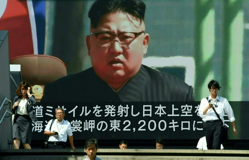 TOPSHOT - Pedestrians walk in front of a large video screen in Tokyo broadcasting a news report showing North Korean leader Kim Jong-Un, following a North Korean missile test that passed over Japan on September 15, 2017.
North Korea fired a ballistic missile over Japan and into the Pacific on September 15, responding to new UN sanctions with what appeared to be its furthest-ever missile flight amid high tensions over its weapons programmes. / AFP PHOTO / Toru YAMANAKA