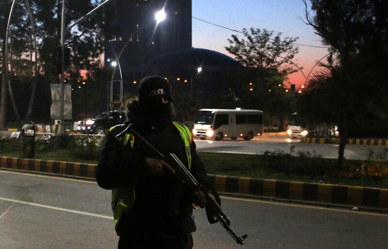 Security officials stand guard as the Australian cricket team is escorted to a hotel on their arrival in Islamabad. EPA