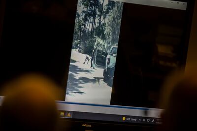 Prosecutor Linda Dunikoski shows an image from a video showing Ahmaud Arbery, left, stumbling to the ground near Travis McMichael, right, during the trial of Greg McMichael and his son, Travis McMichael, and a neighbor, William "Roddie" Bryan in the Glynn County Courthouse, Monday, November 15, 2021, in Brunswick, Georgia. AP